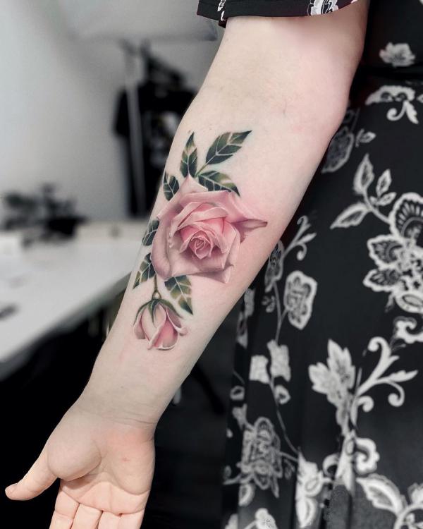 Pink rose and rosebud tattoo on arm