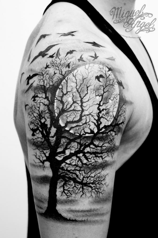 Circular tree tattoo on the right shoulder blade