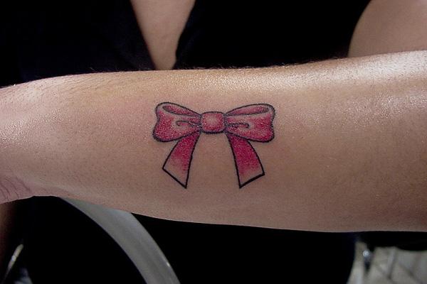 Single needle ribbon tattoo placed on the upper arm.