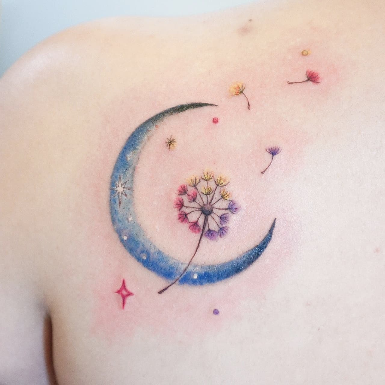 Watercolor style tattoo of a dandelion flower on the