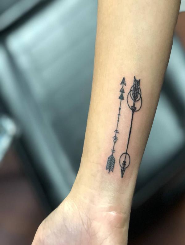Two arrows in different direction wrist tattoo