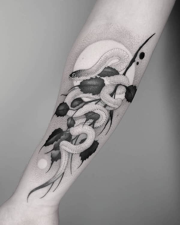 Black and white snake tattoos on the left forearm