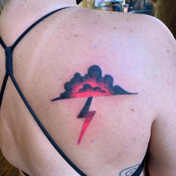 Minimalistic red lightning bolt tattoo done on the