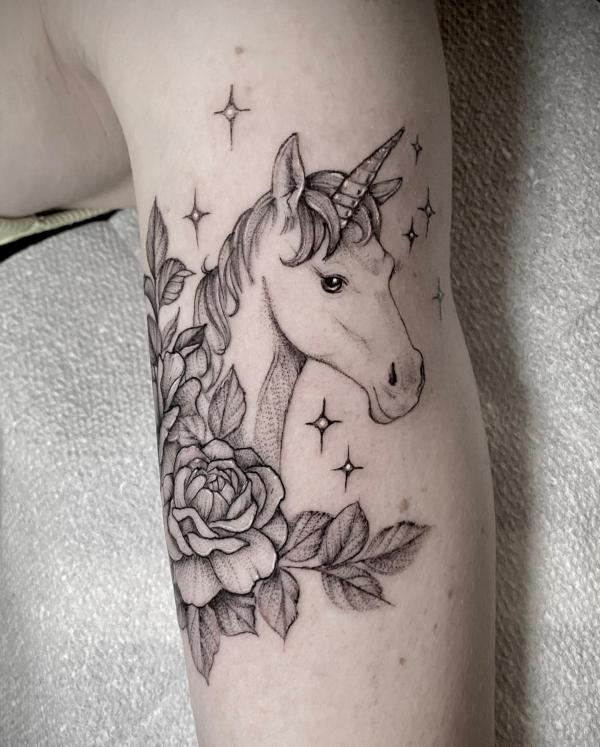 Tiny unicorn tattoo on the inner forearm.