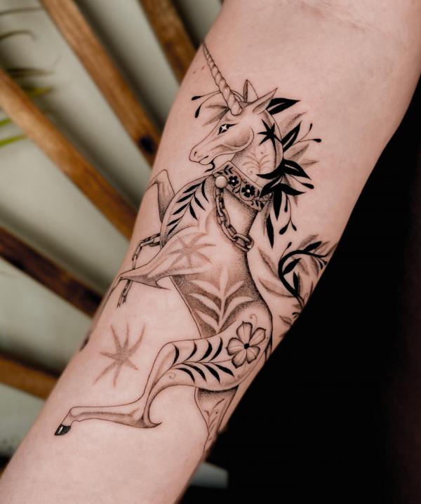 Minimalist unicorn tattoo on the wrist.