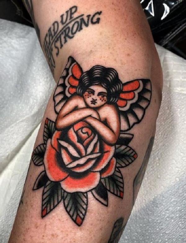Traditional style cupid tattoo placed on the shin.