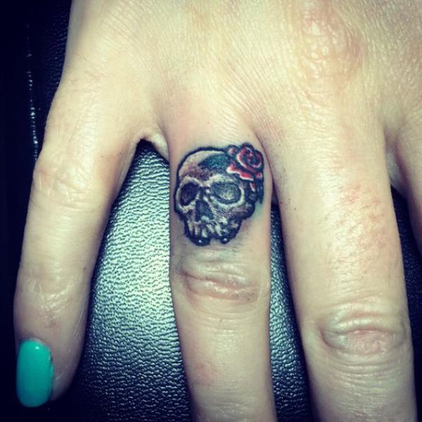 Baby Name Tattoos - Fingers with a tattoo of a male skull and a female skull,  this must be couples. Image by: lastsparrowtattoo.com Visit our website:  http://www.BabyNameTattoos.com/ | Facebook