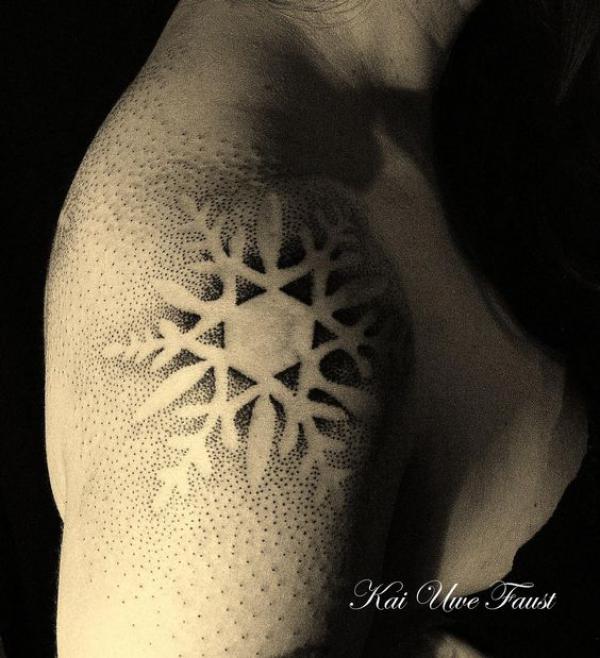 Snowflake tattoo on the inner forearm.