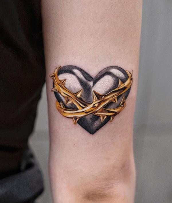 Barbed wire wrapped heart symbol back of arm tattoo