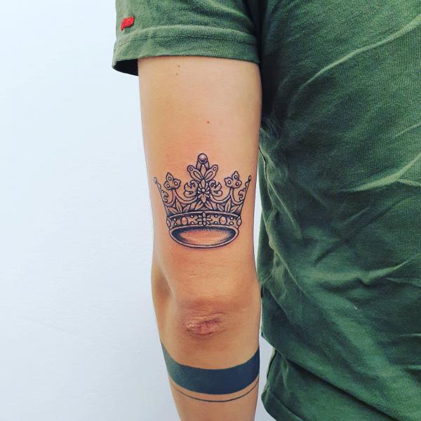 Crown back of arm tattoo