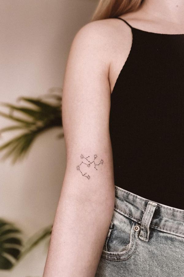 Minimalist Sagittarius constellation tattoo above inner elbow
