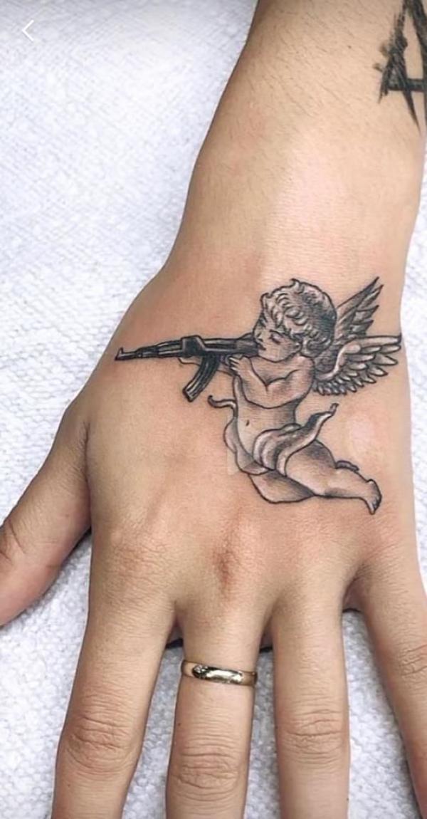 Cupid with gun hand tattoo