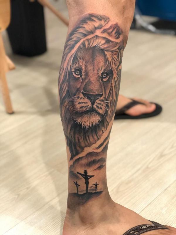 Lion king with 3 cross tattoo on lower leg